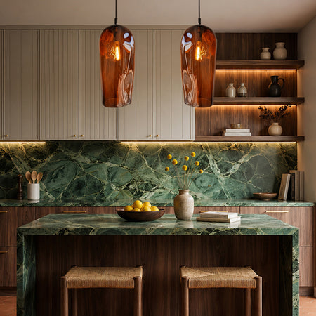 Marea Amber handblown glass pendant lights with black fittings over a luxury kitchen island, designed by Contemporary Co Australia.