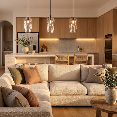 Three Marea Clear Australian made handblown glass pendant lights with black fittings in a contemporary open-plan kitchen and living interior.
