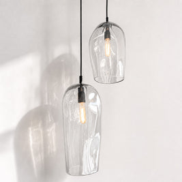 Marea Clear Australian made handblown glass pendant lights with black fittings, shown illuminated.