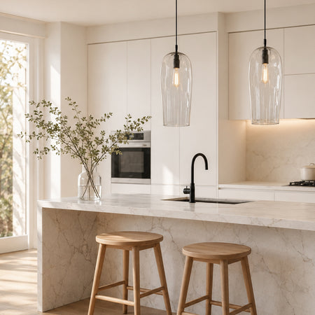 Marea Clear handblown glass pendant lights with black fittings over a modern kitchen island, designed by Contemporary Co Australia.