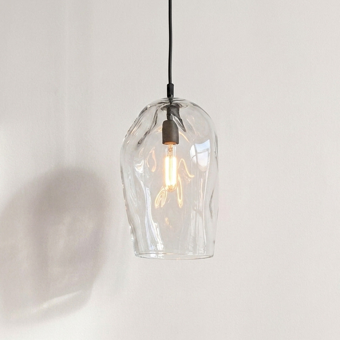 Marea I Clear Australian made handblown glass pendant light with black fitting, shown illuminated.
