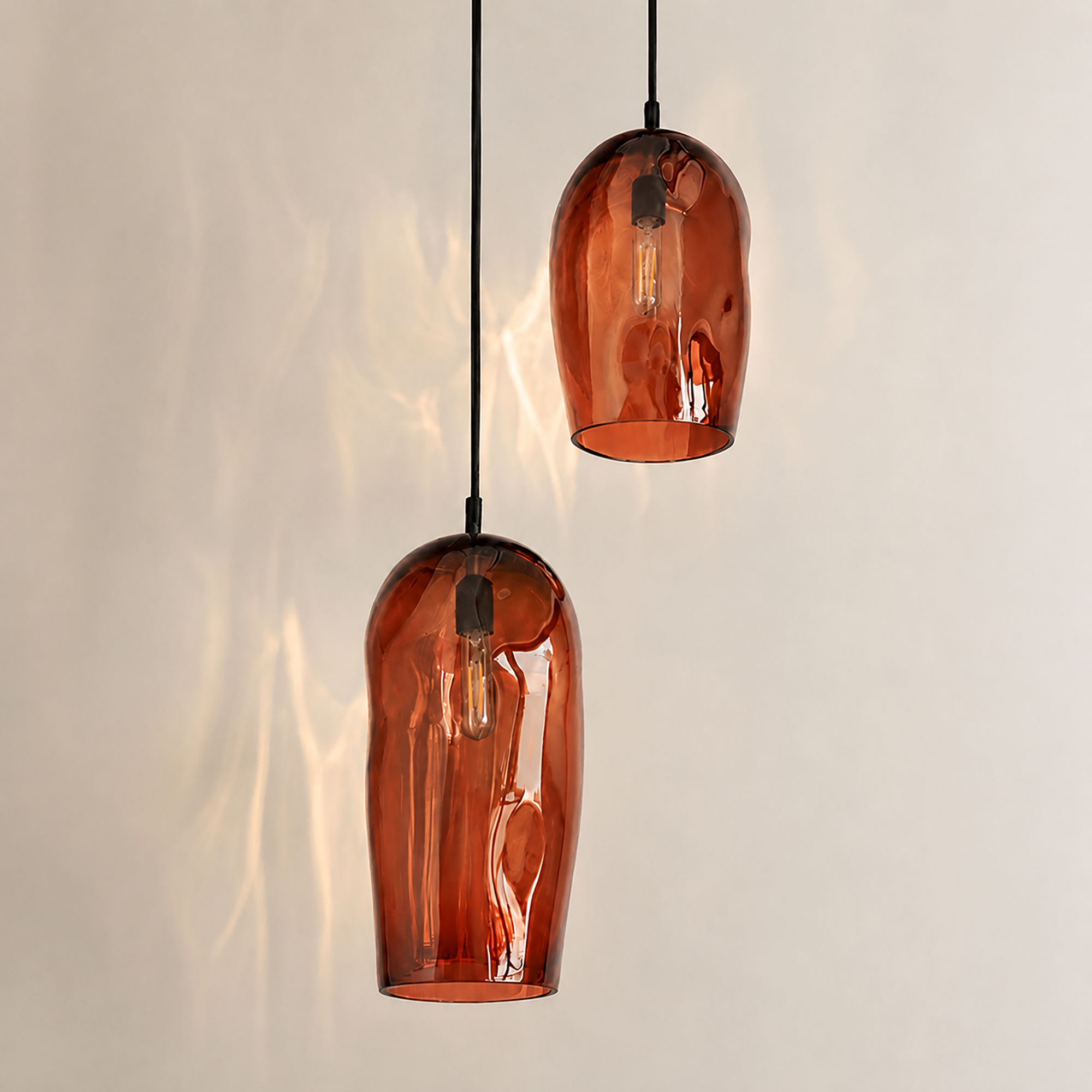 Marea I handblown amber glass pendant lights by Llewelyn Ash suspended together in a contemporary interior.