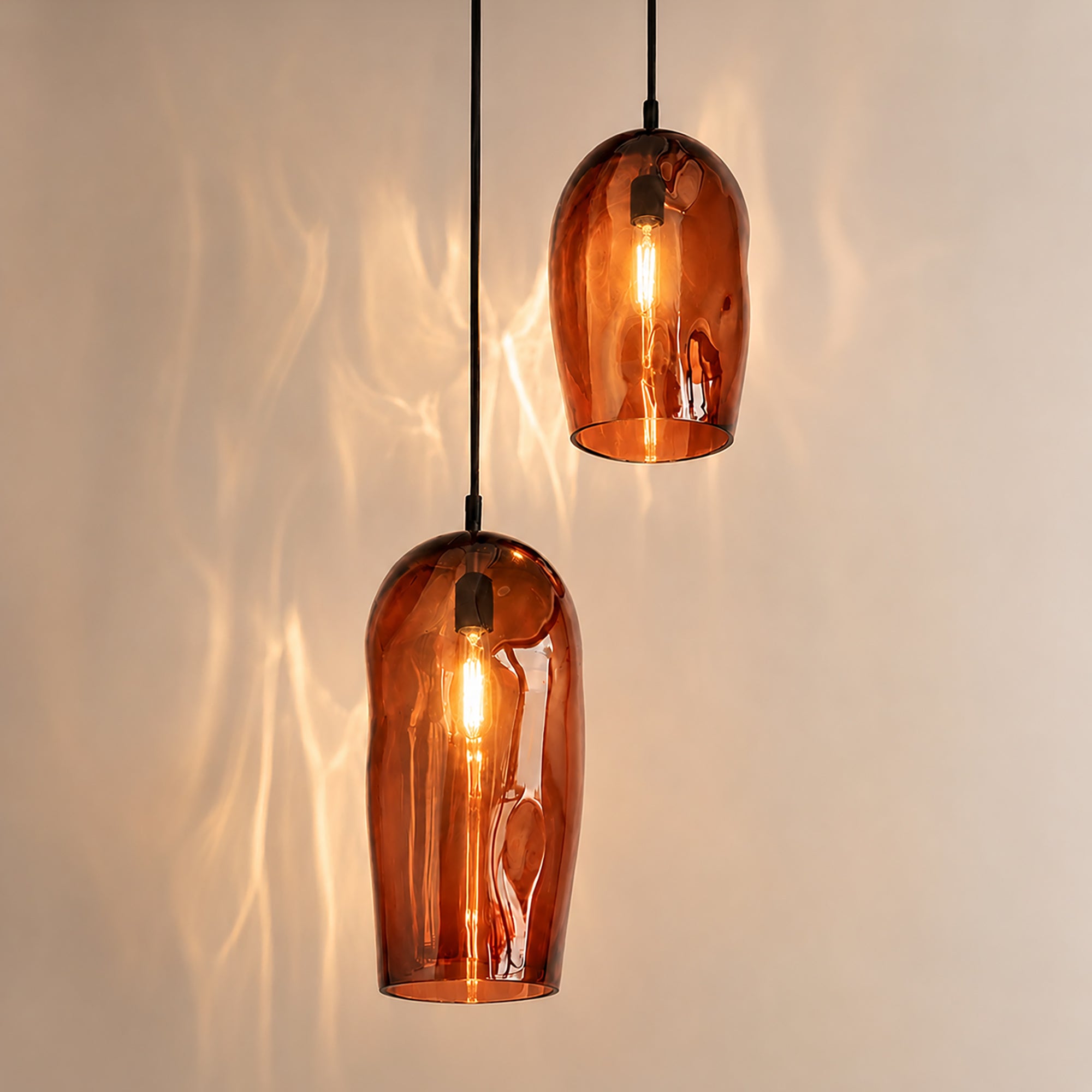 Marea I handblown amber glass pendant lights by Llewelyn Ash suspended together in a contemporary interior.
