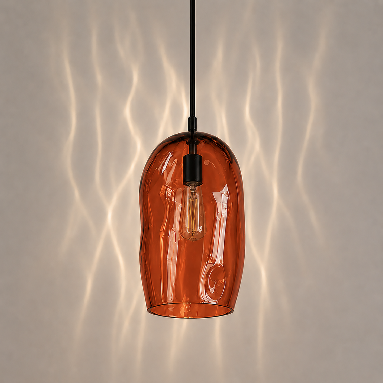 Marea I handblown amber glass pendant light by Llewelyn Ash with matte black hardware.