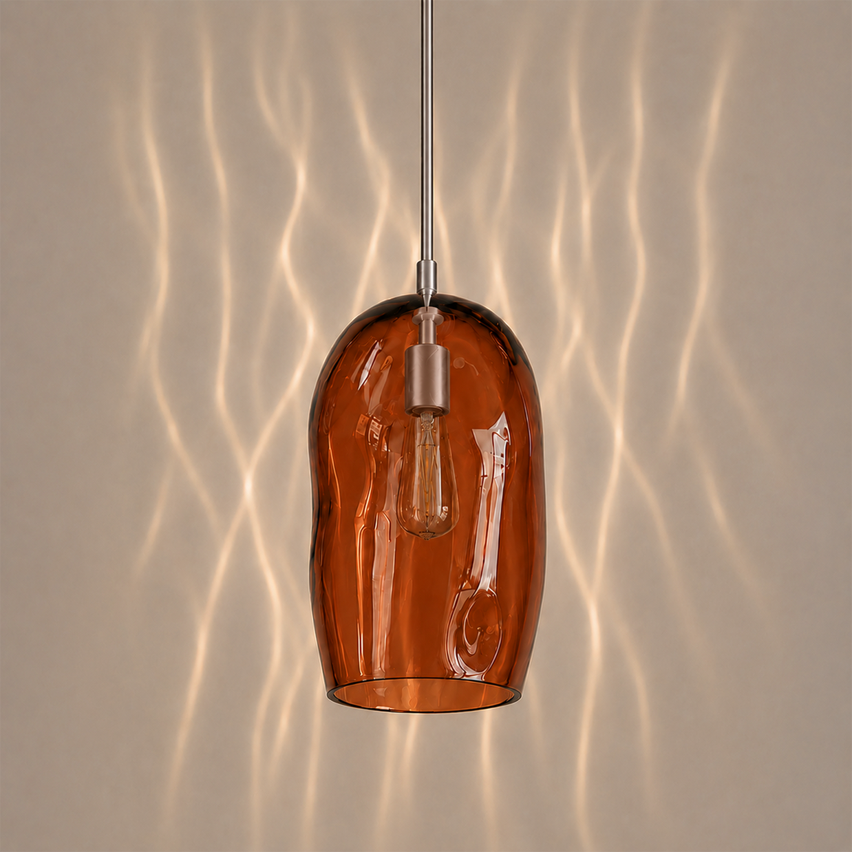Marea I amber glass pendant light creating warm ambient lighting in a contemporary interior.