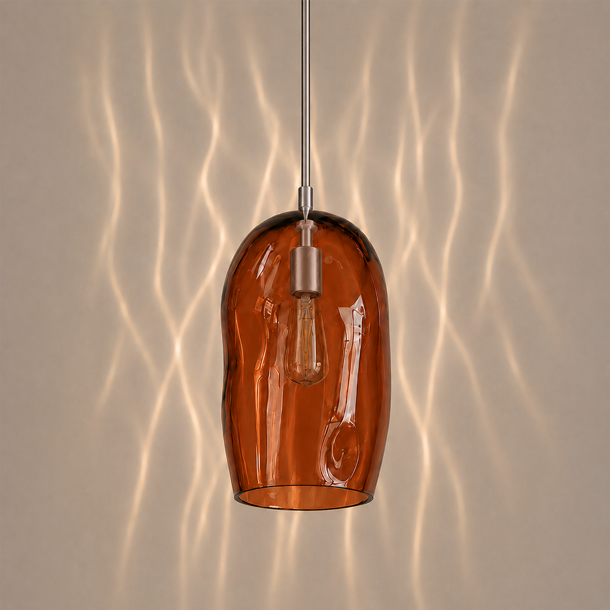 Marea I amber glass pendant light creating warm ambient lighting in a contemporary interior.