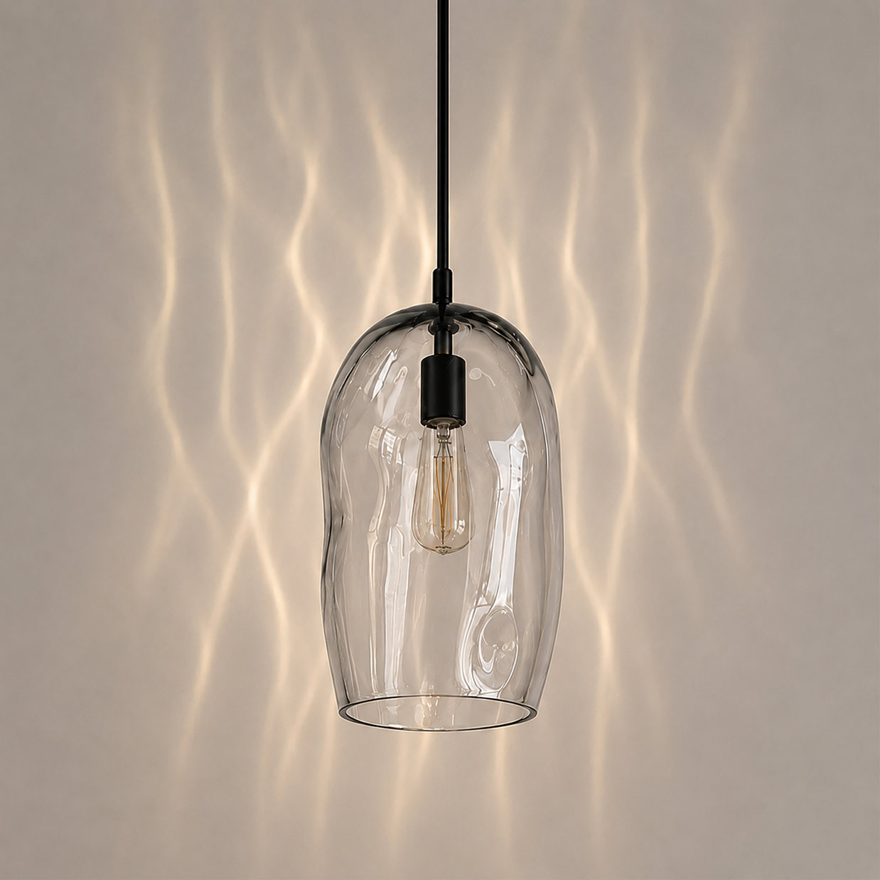 Marea I handblown clear glass pendant light by Llewelyn Ash with matte black hardware.